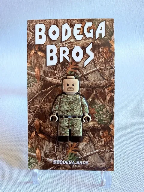Bodega Bros Pin Stone Cold Steve Austin Camo Minifig style.