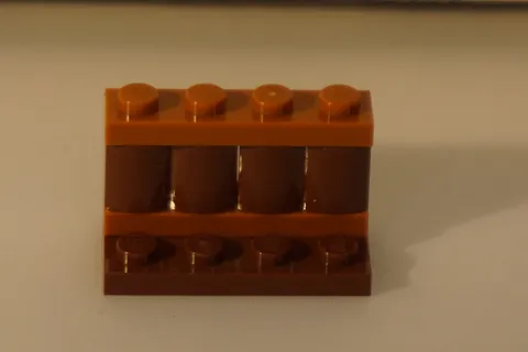 W - LEGO Brown Brick is a 1x4 Plate, specifically part #9710 used for LEGO castl