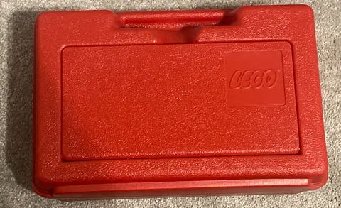 1985 LEGO red plastic storage and carrying case with assorted LEGO pieces. OFNW