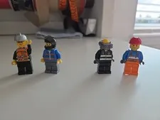 small bag of lego pieces and four characters