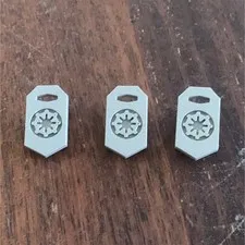 Three 3D printed grey imperial Lego shields.