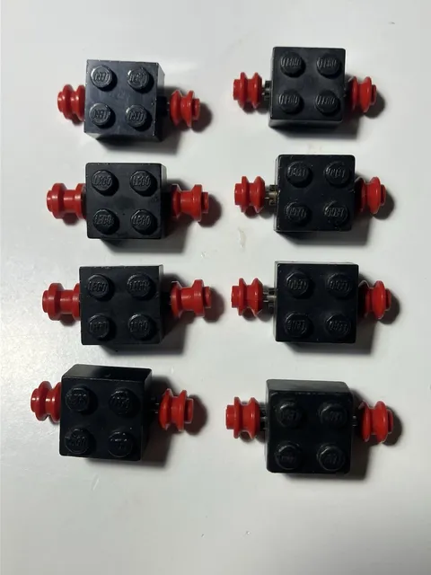8 LEGO 2x2 Black Axle Brick with Red Single Wheels (Part ID 3137c01)